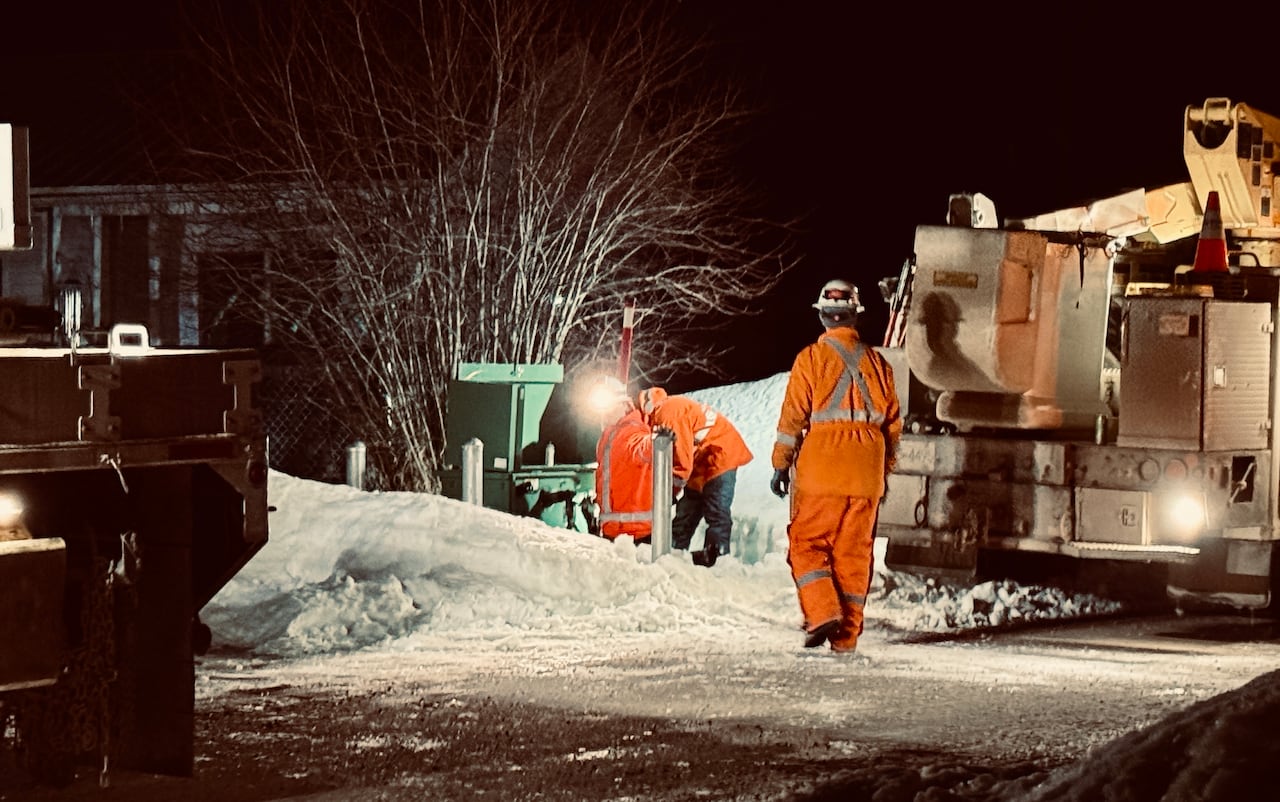 Crews in reflective gear in the dark.
