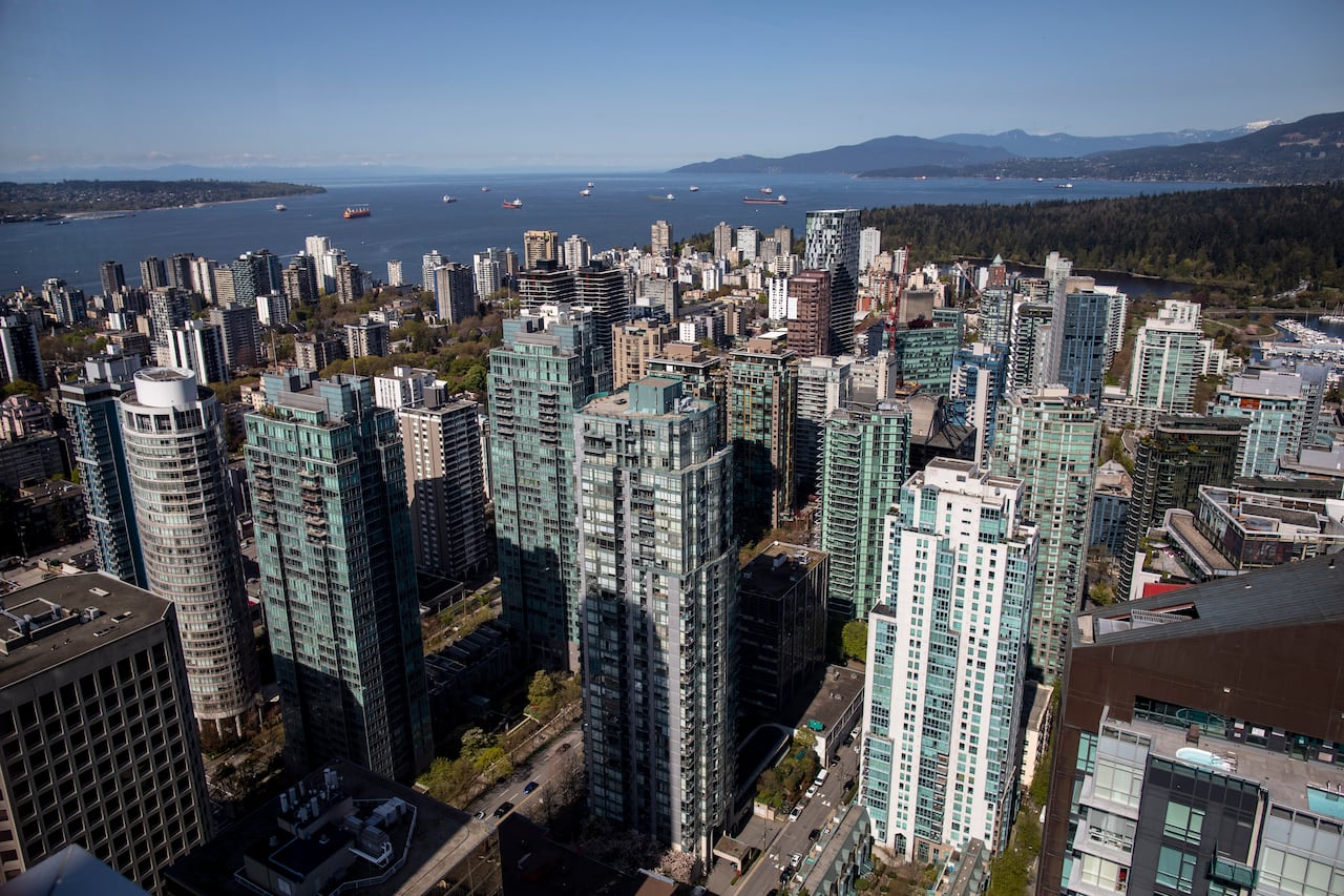 A drone photo of downtown Vancouver from above with Burrard Inlet in the distance
