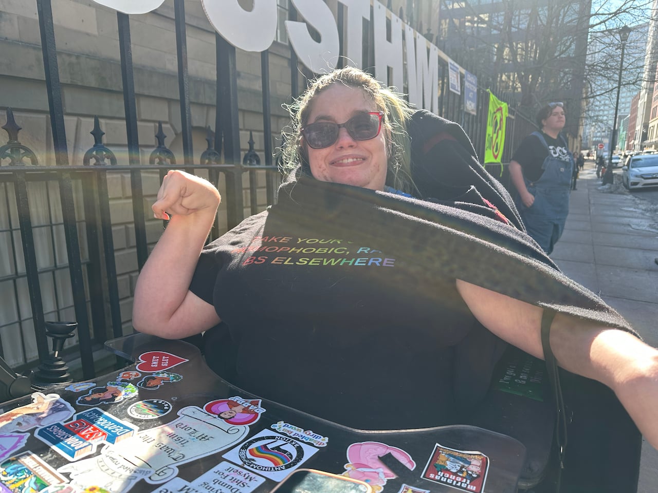 A woman in a wheelchair smiles.