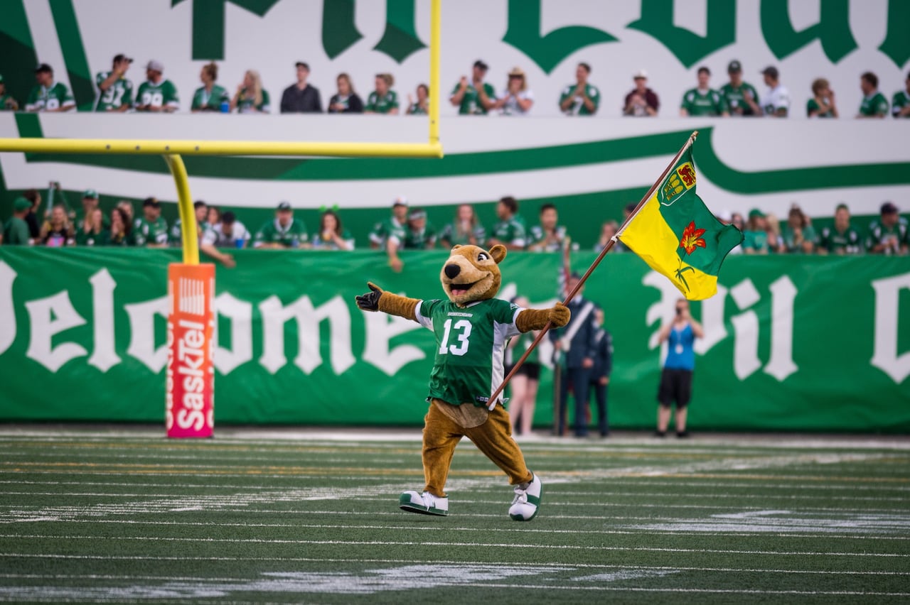 Gopher mascot running across a football field