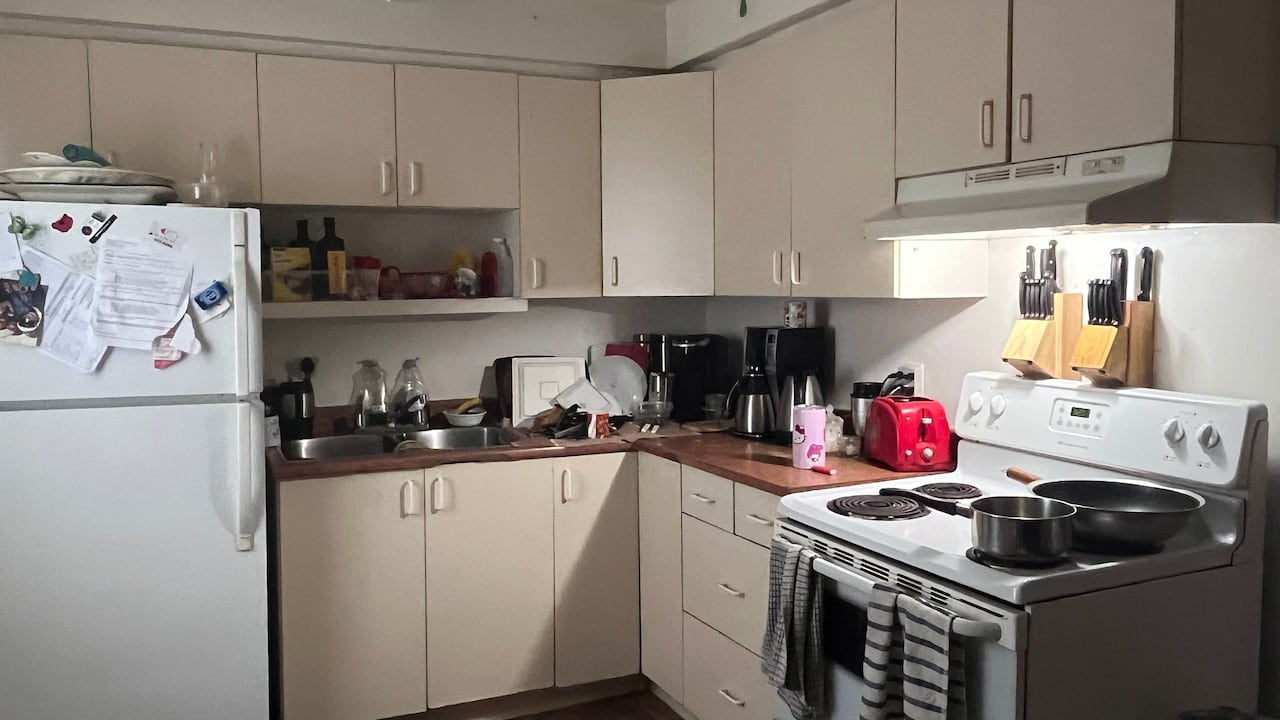 A kitchen with a stove to the right and fridge to the left.