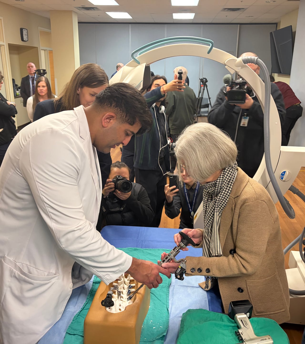 A doctor shows a patient spine surgery equipment.