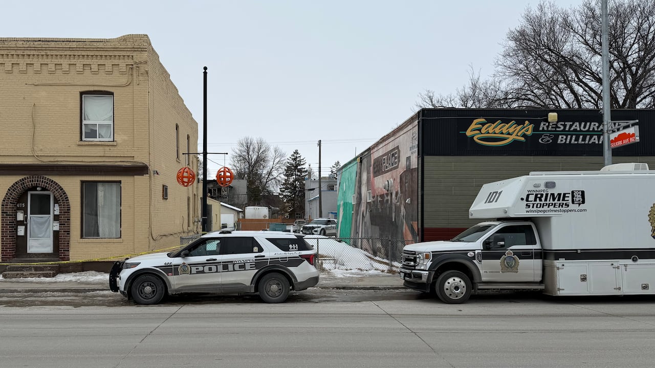 Three police vehicles are parked along a street.