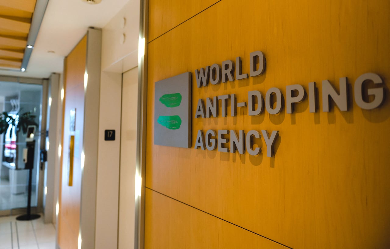 A sign that reads, 'World Anti-Doping Agency,' is seen on a wall.