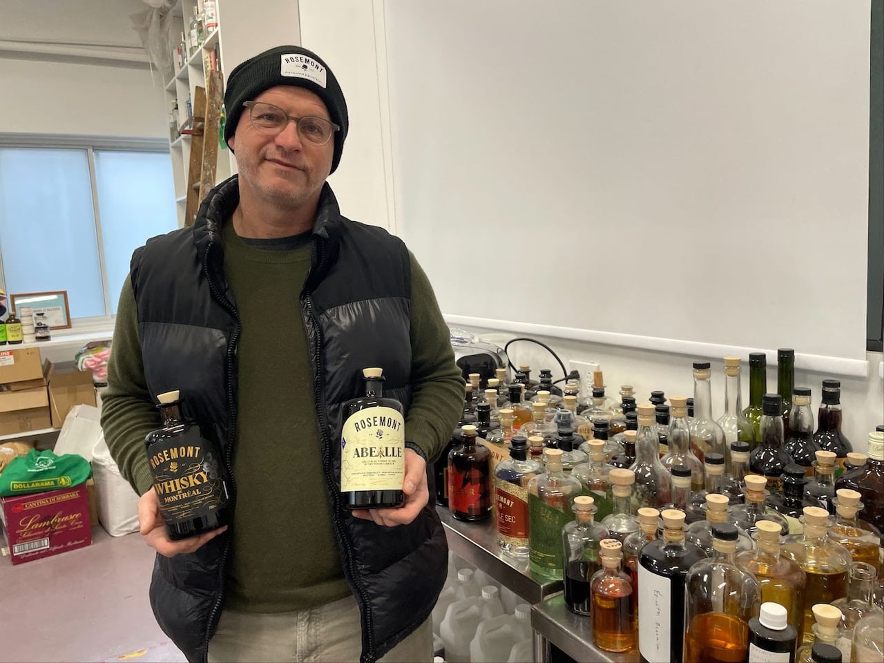 A man holding bottles of whisky. 