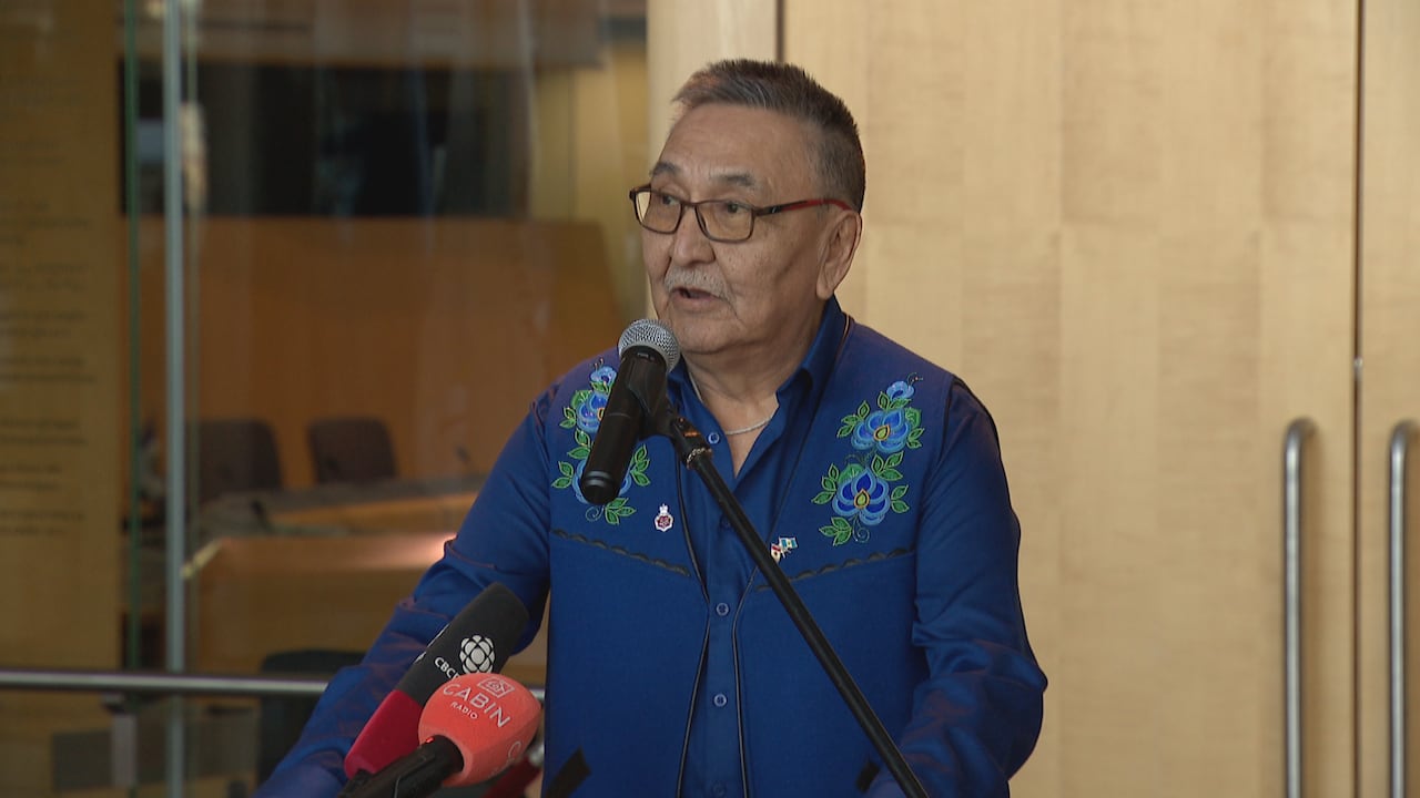 A man in a blue shirt at a podium