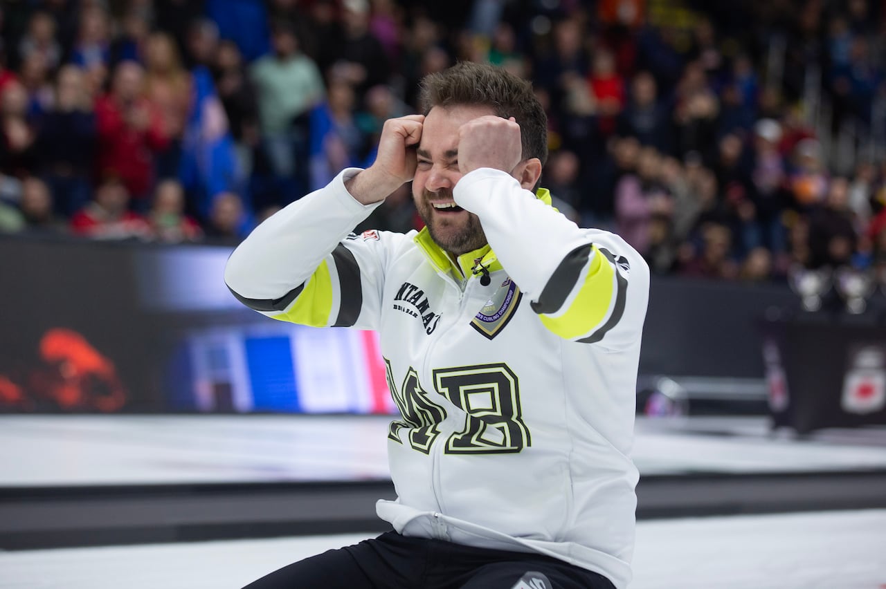 A man on his knees with his hands to his face.
