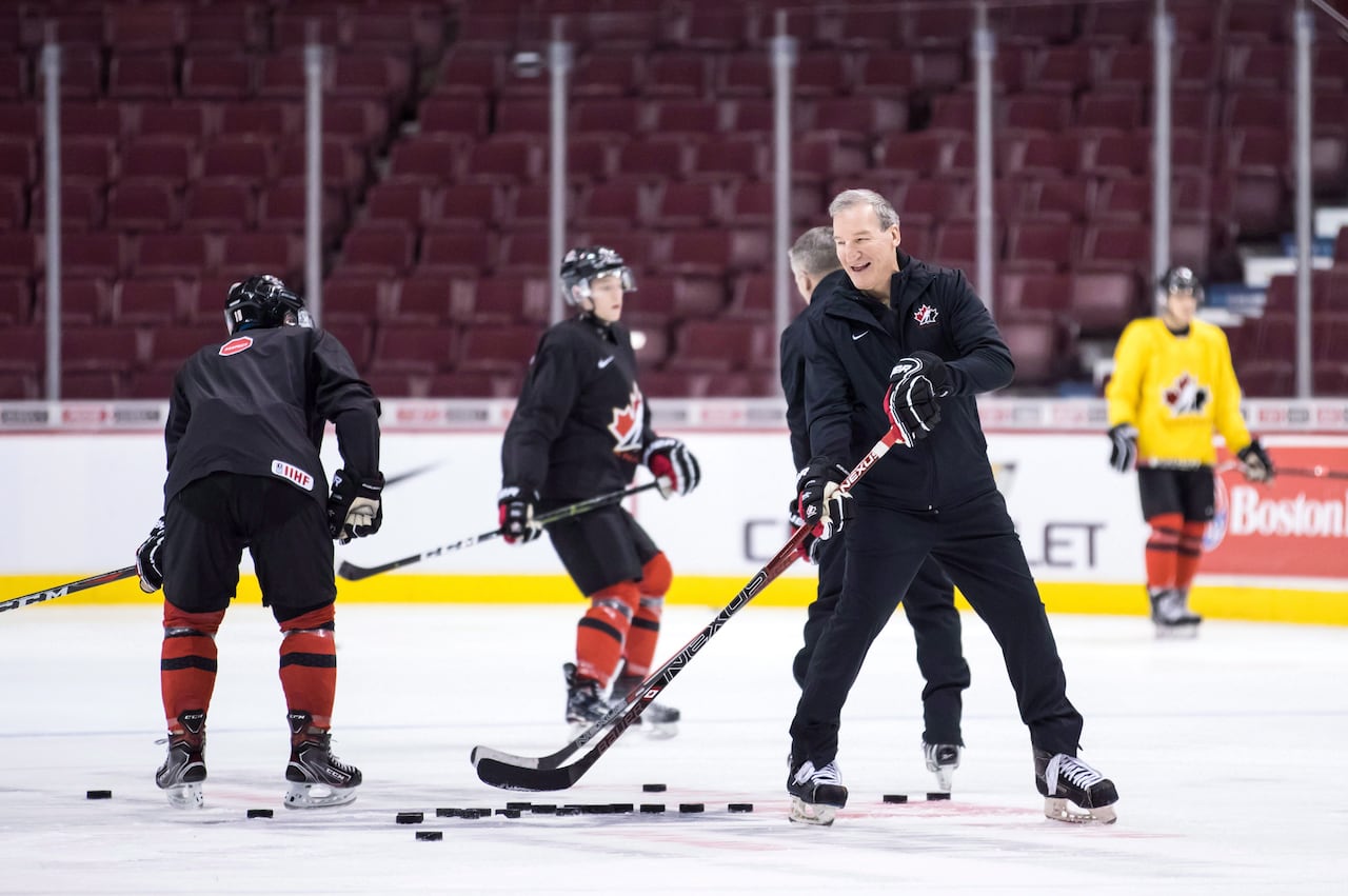 Several hockey players skating on a rink.