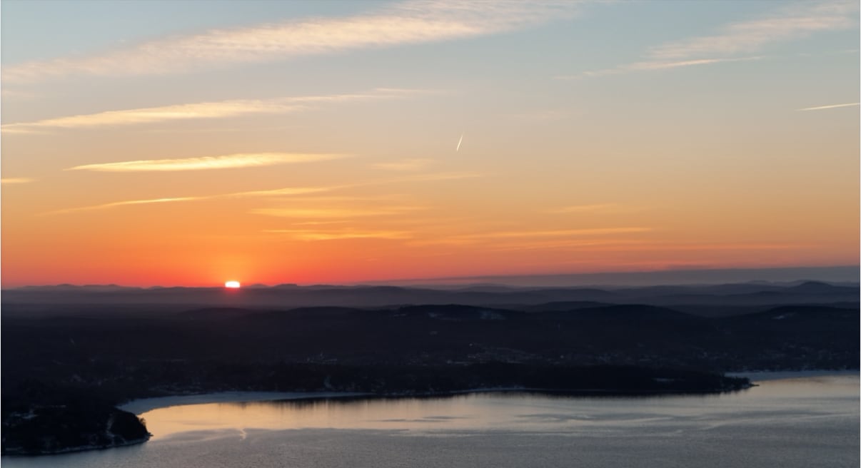 An orange sunset over a river.
