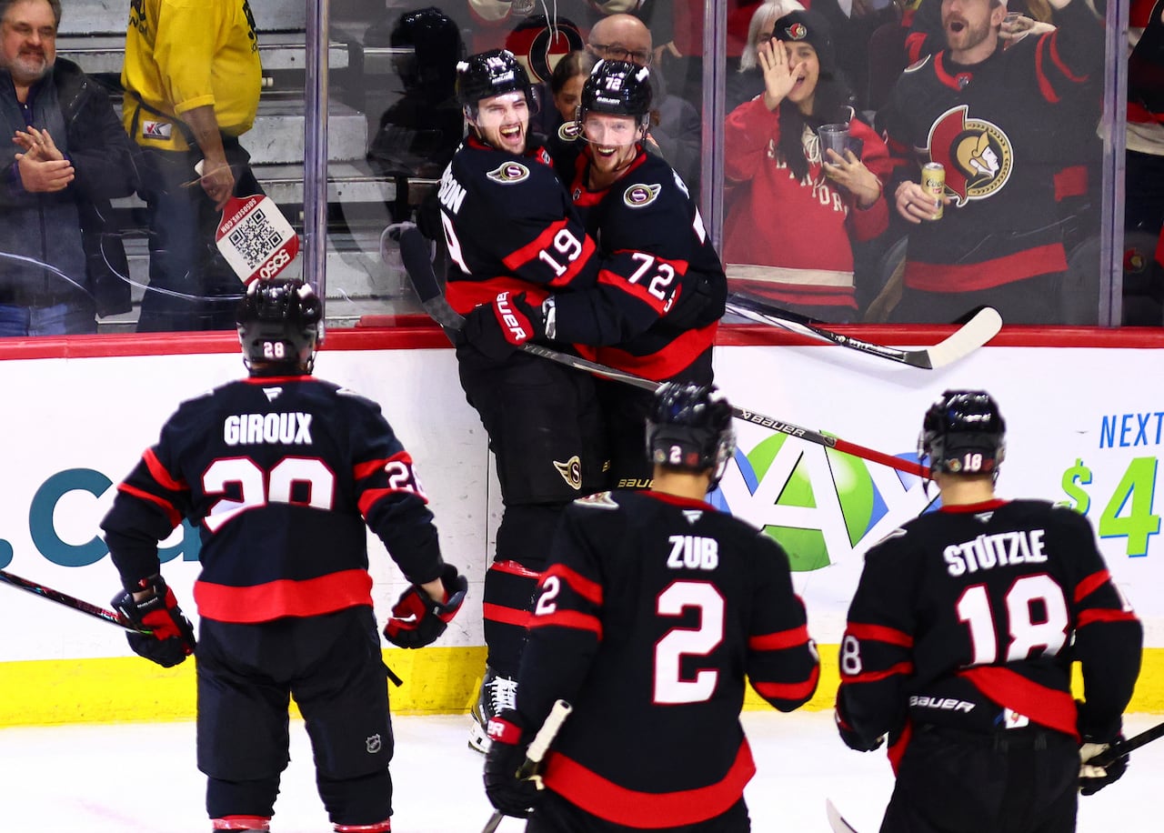 A group of hockey players celebrate a goal.