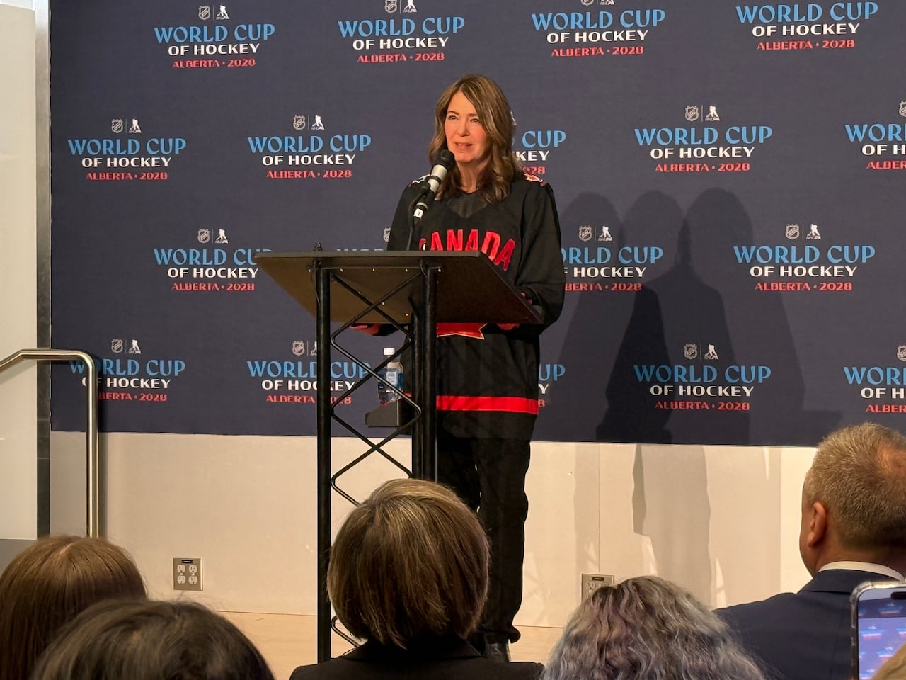 A woman stands behind a podium.