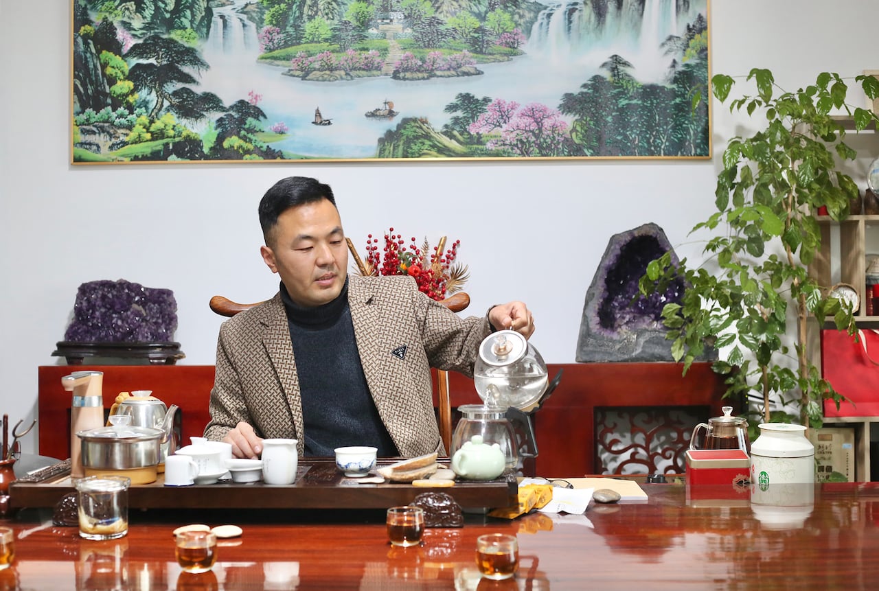A man in an office pours tea.