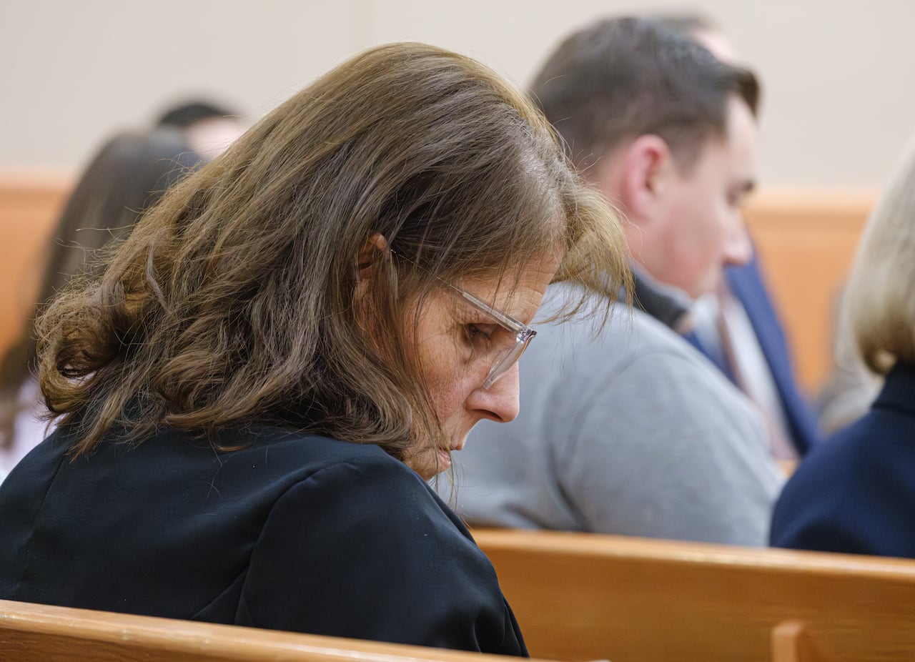 A woman sits in court.