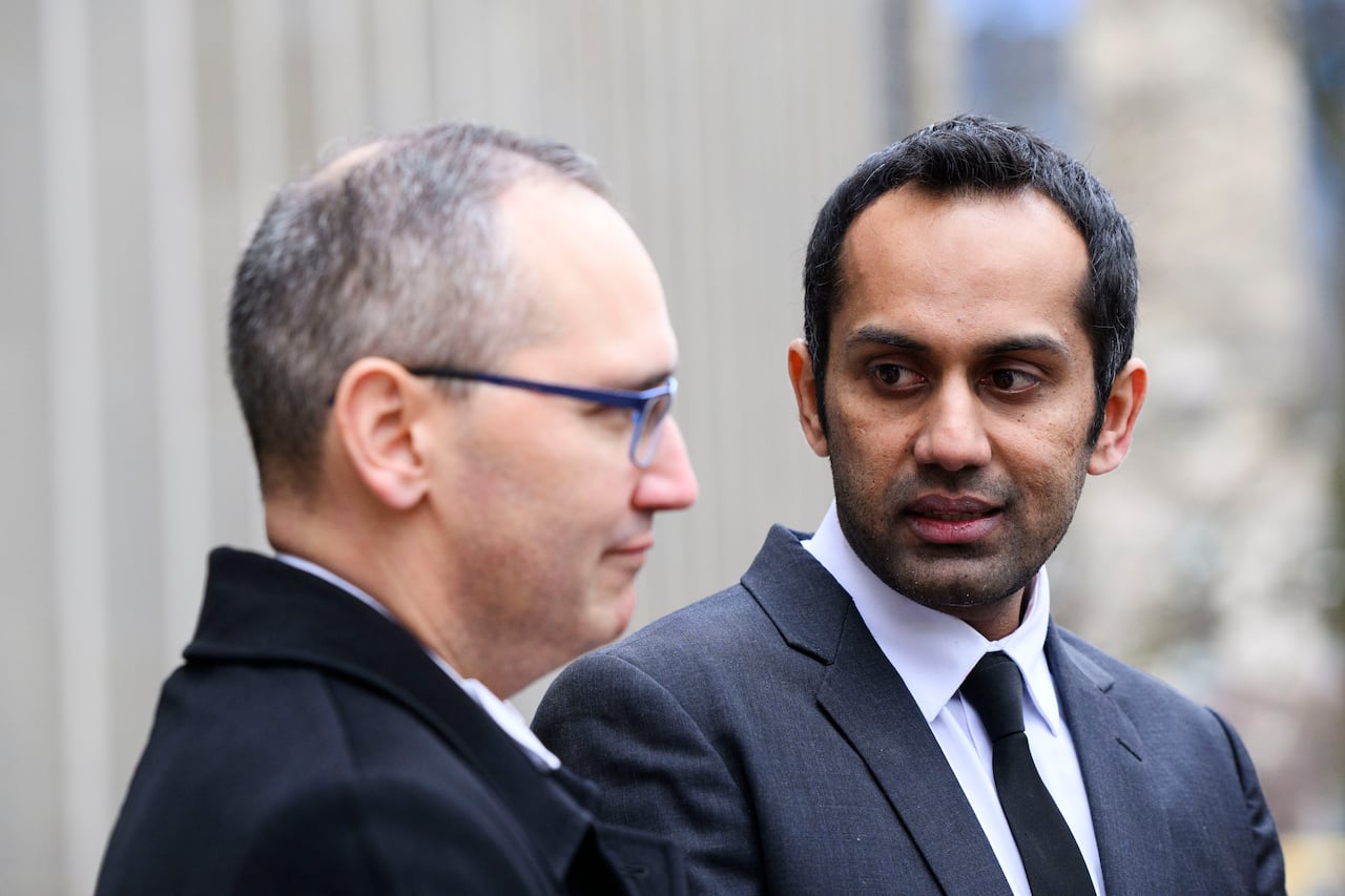 A man speaks while looking at another man.