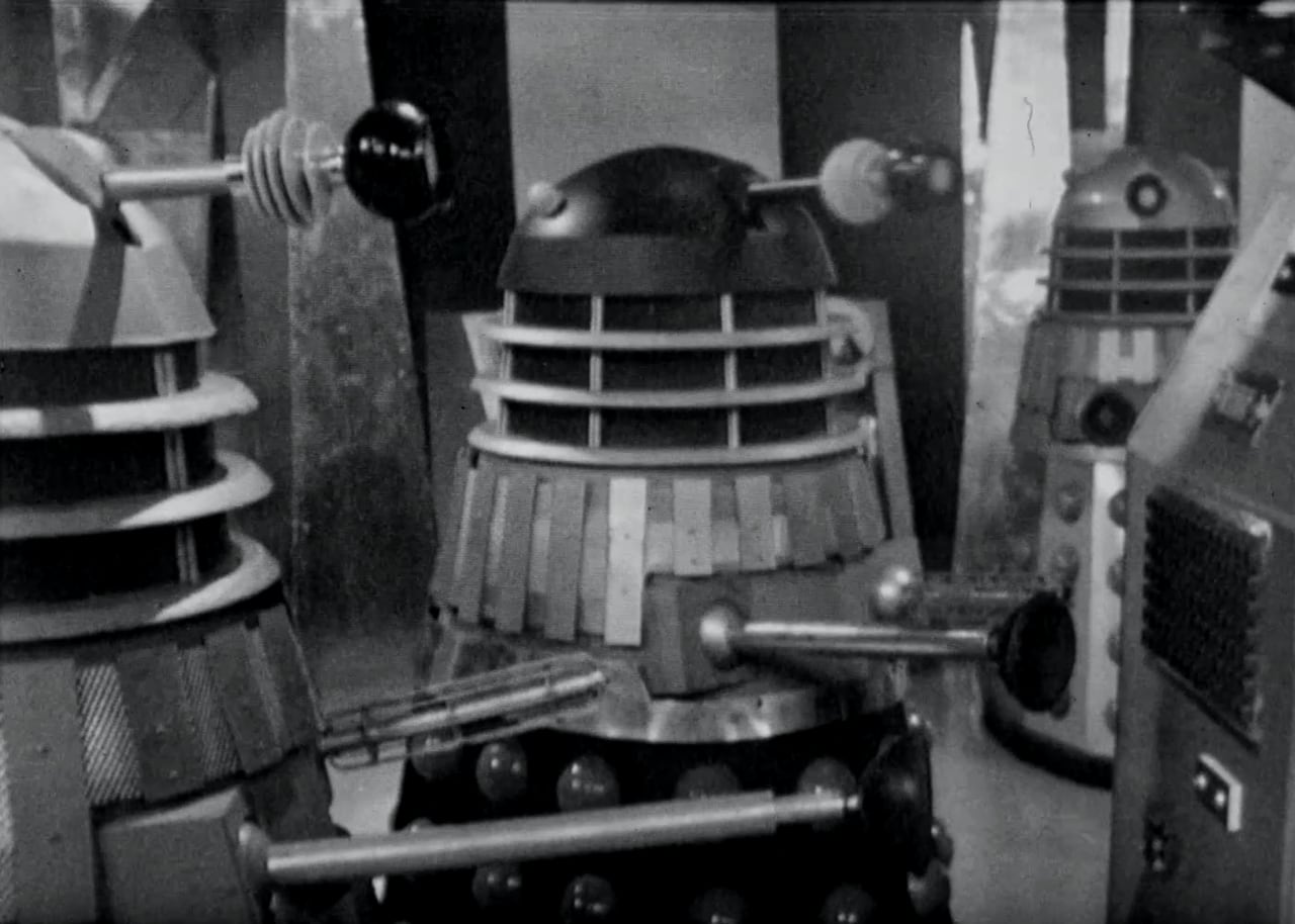 a black and white photo showing a group of metal robot-looking objects.