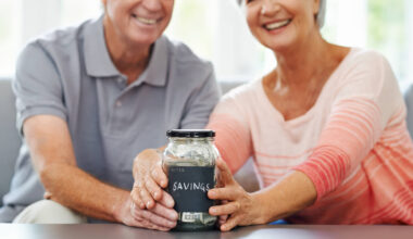 senior couple proudly posing with their savings jar
