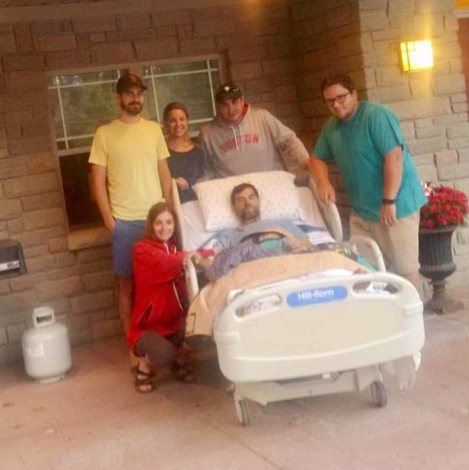 Family surrounds man in hospital bed