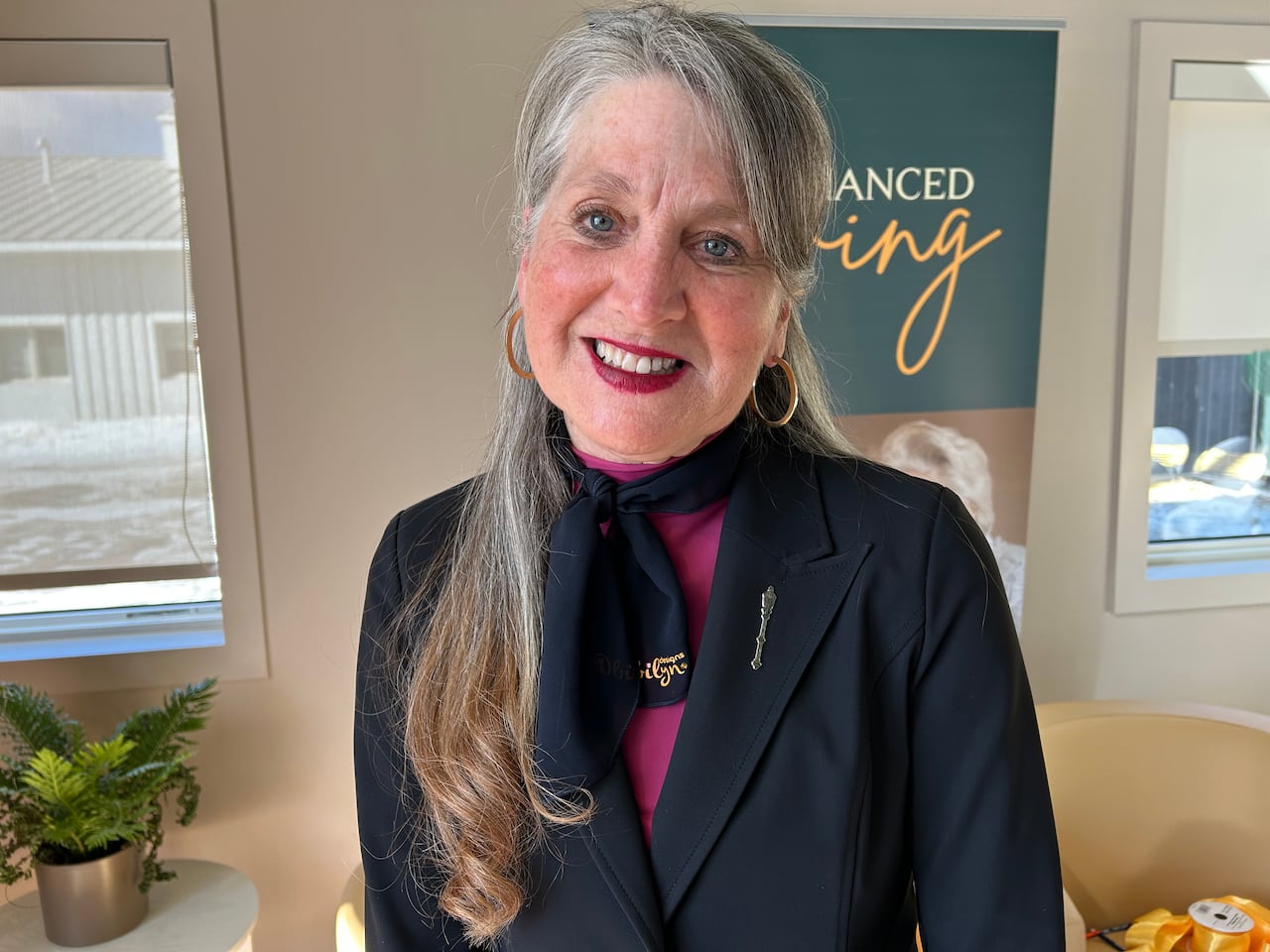 A lady with grey hair and blue coat