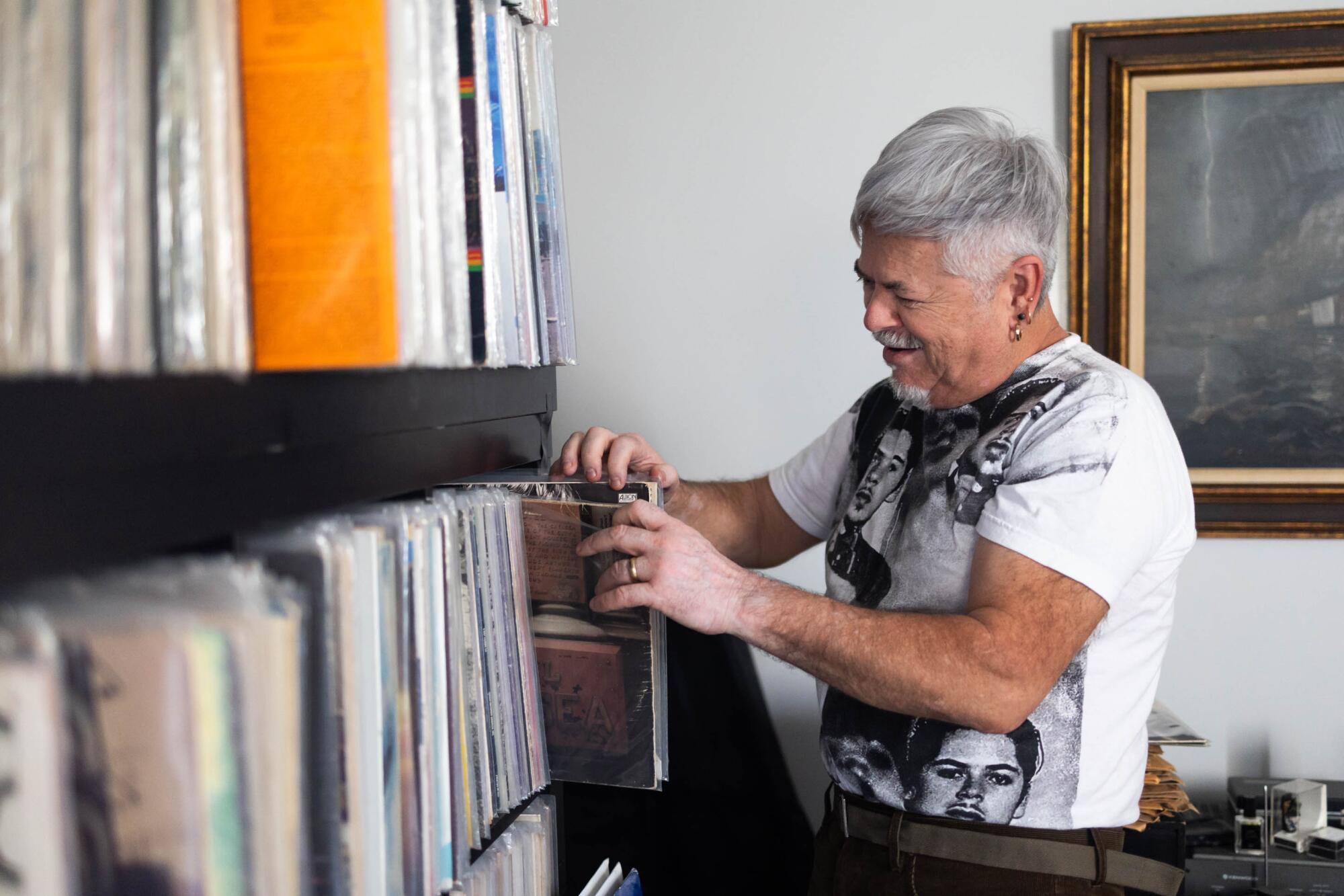 A man looks through photos on a shelf