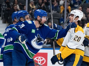 Marcus Pettersson (29) provides some pushback for the Vancouver Canucks against the Nashville Predators' Justin Barron (20) during the second period at Rogers Arena on Thursday night