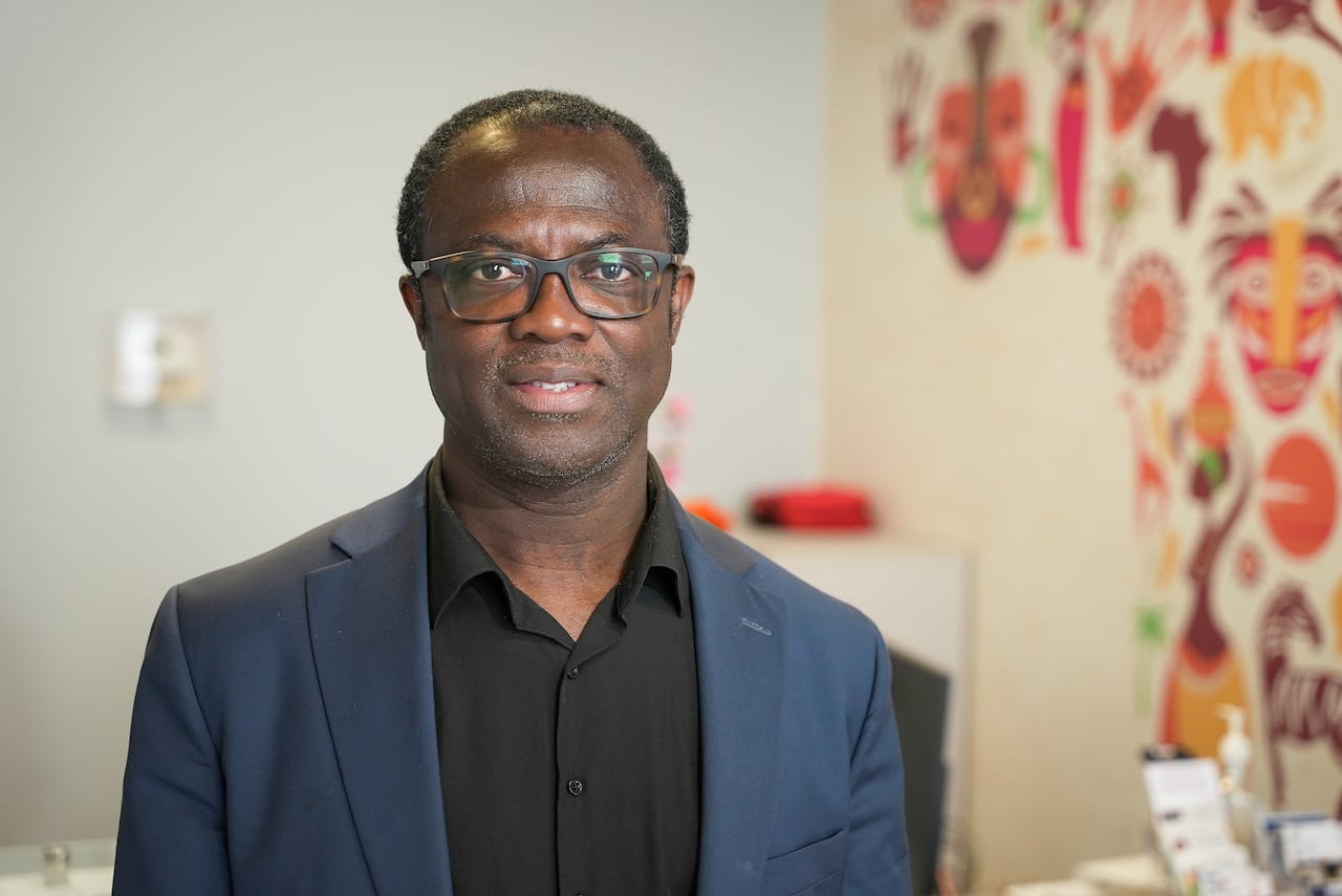 A man wearing a blue blazer and black shirt