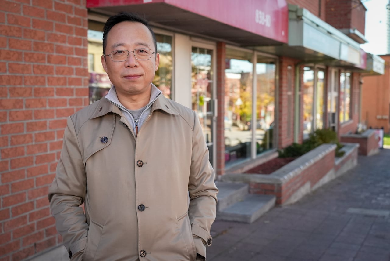 A man stands in front of a building