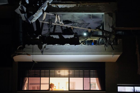Israeli security forces inspect an apartment struck by an Iranian missile that killed two people in Ramat Gan, Israel, Wednesday, March 18, 2026. (AP Photo/Ohad Zwigenberg)
