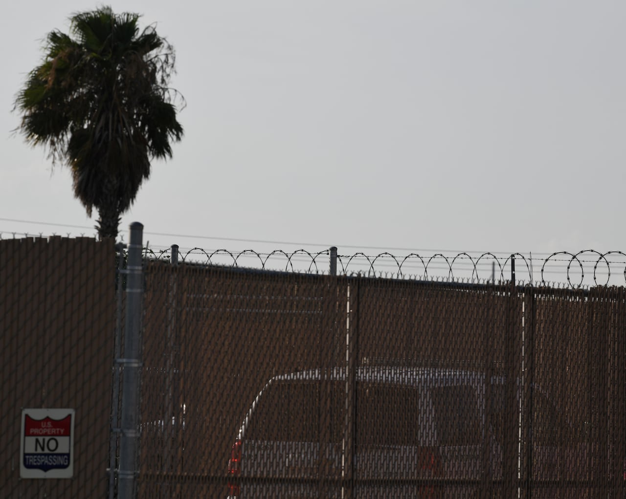 A detention facility behind a chain-link fence.