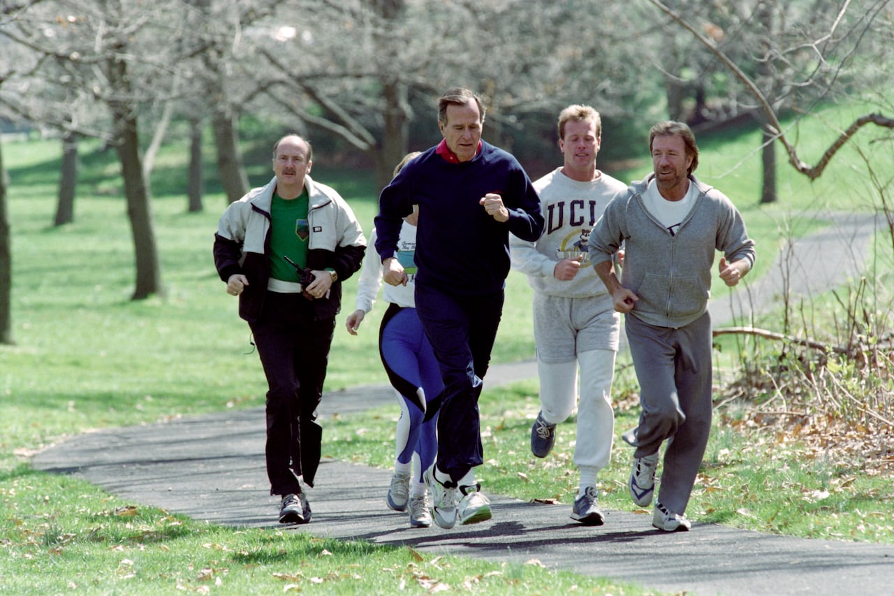 A group of five people jog down a path.