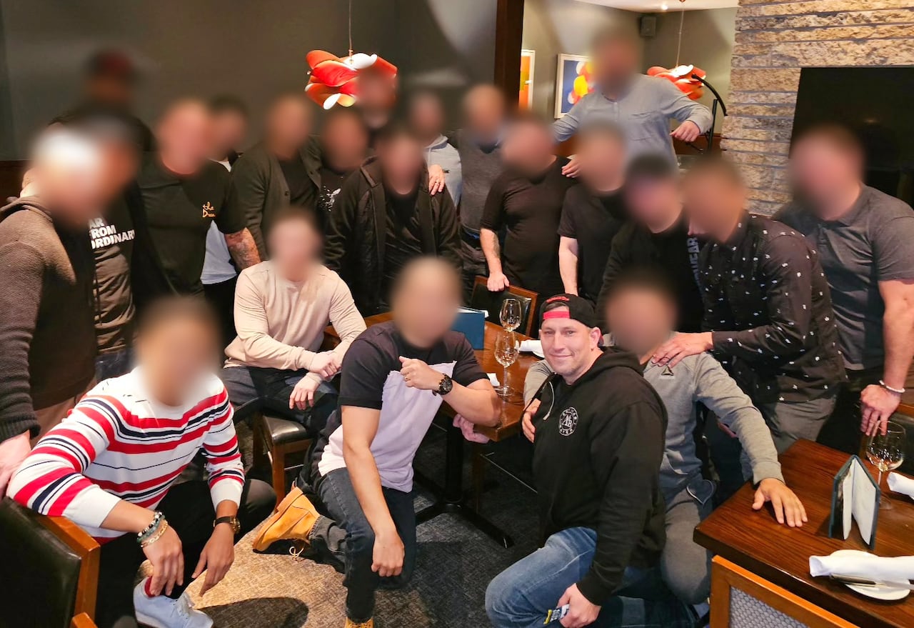 A group of people posing together. All the faces are blurred but one in the front.