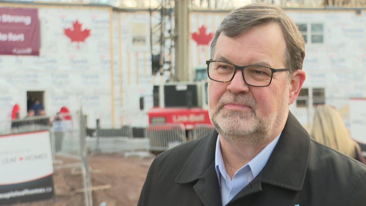 Peter Corbyn stands in front of a construction site.