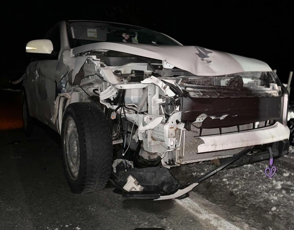 The front of a white car is all crumpled and mangled
