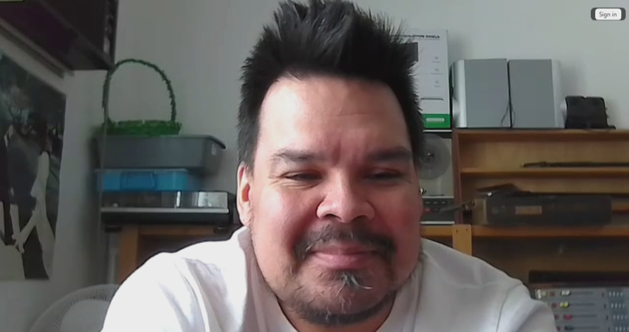 a man with black hair and a beard in a white shirt