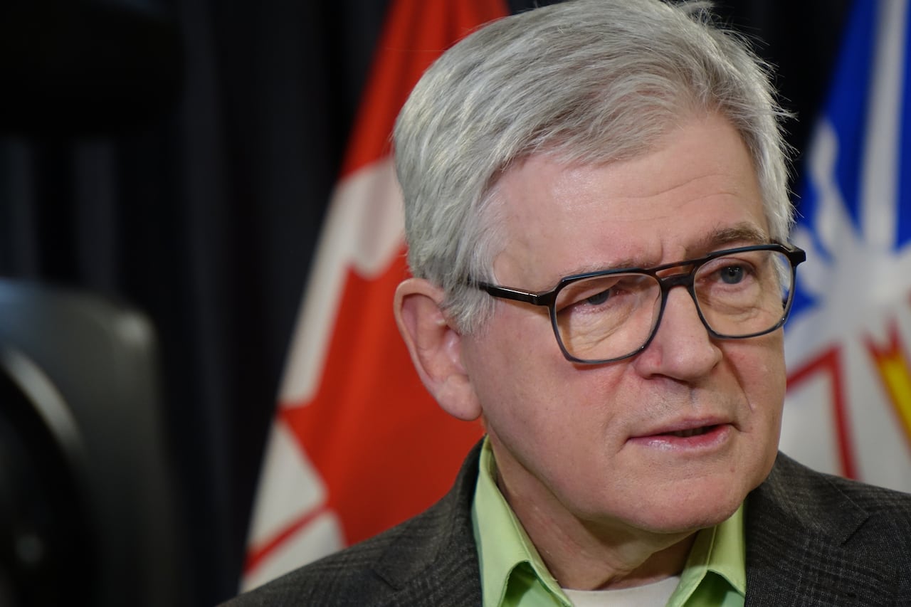A grey-haired man with glasses answers a question.