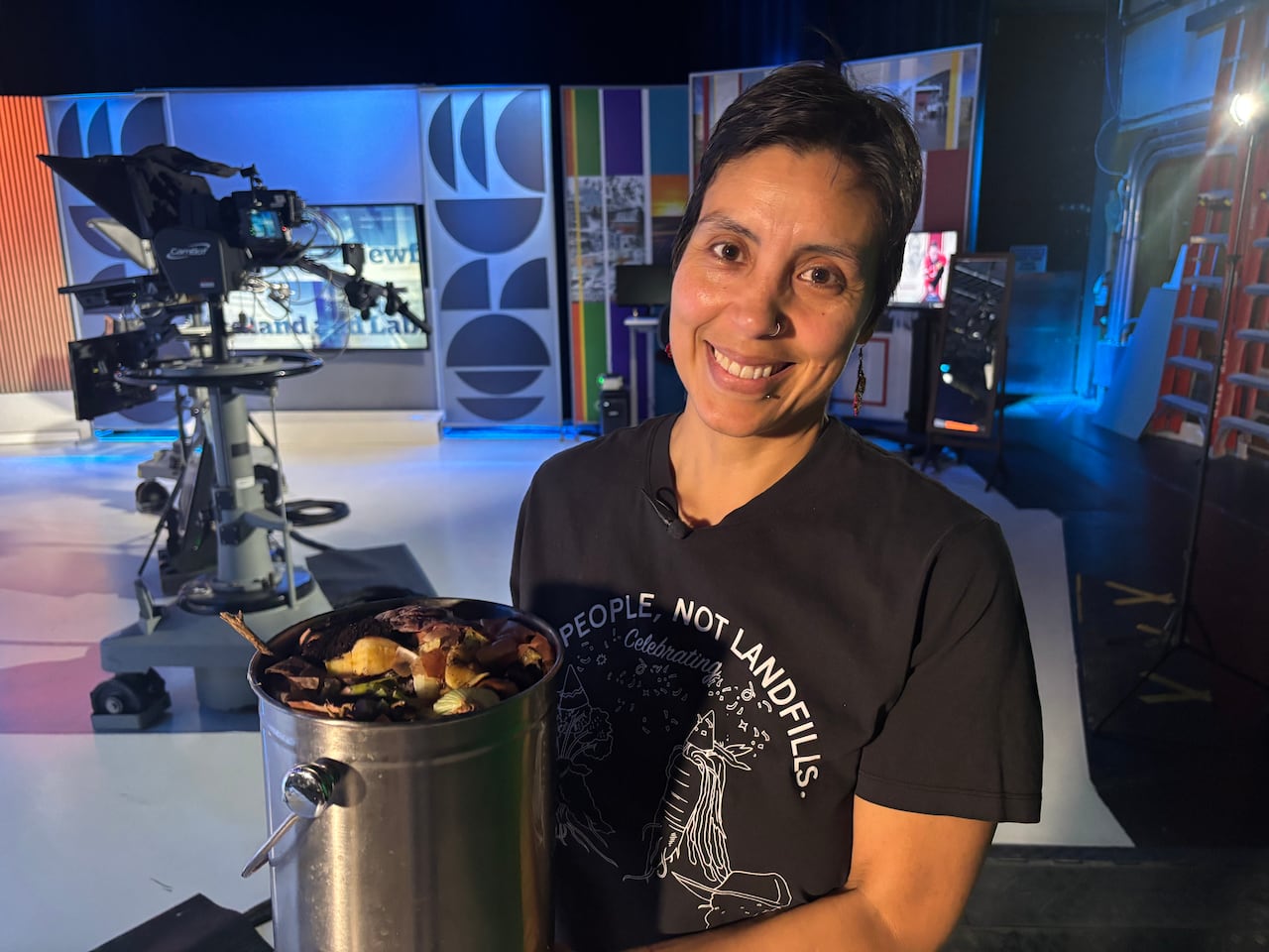 A woman holds a bucket of rotting food.