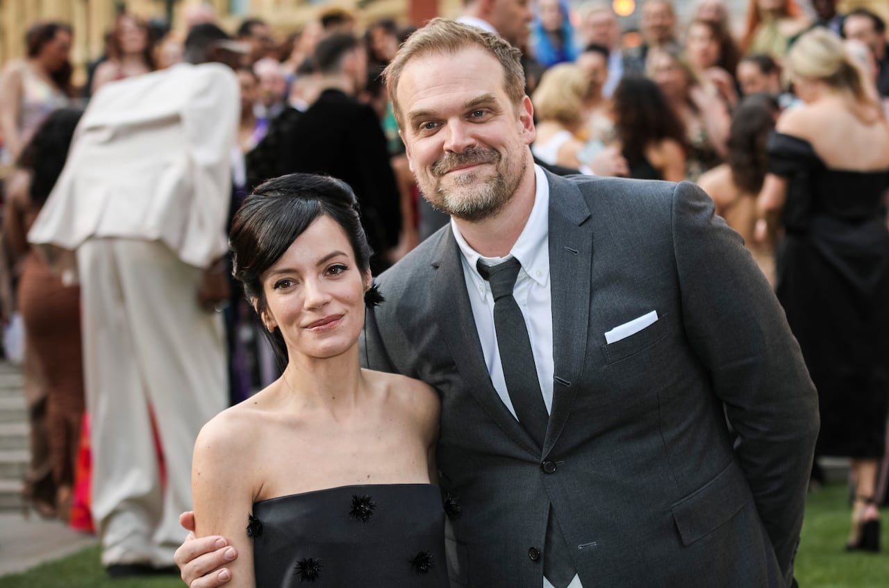 A man and woman pose together in formal clothing at an event