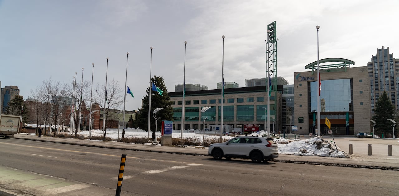 Lowered flags in tribute outside a city hall at the start of spring.