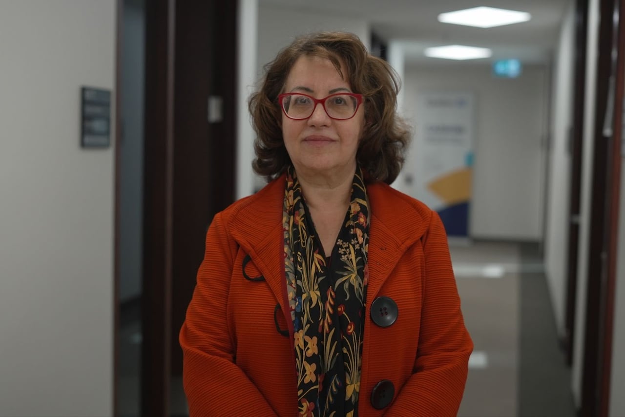 Woman wearing orange jacket and and red glasses