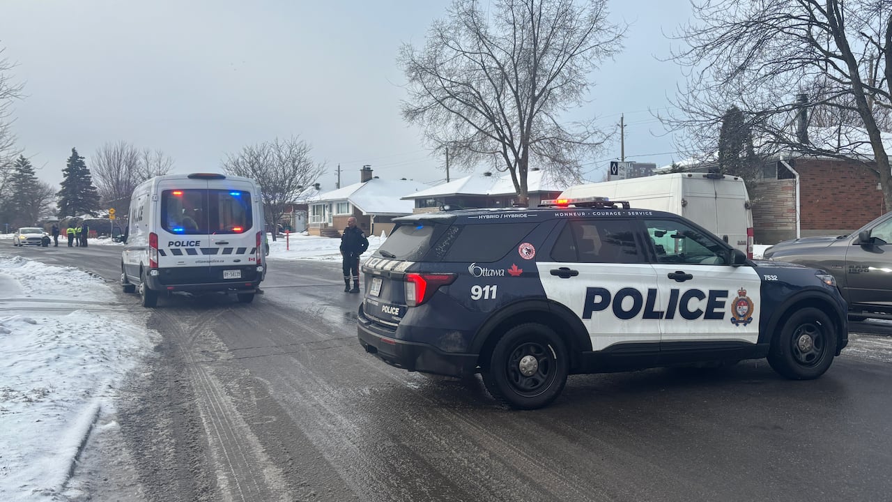 Police block a street to investigate a crash on a snowy early spring morning.