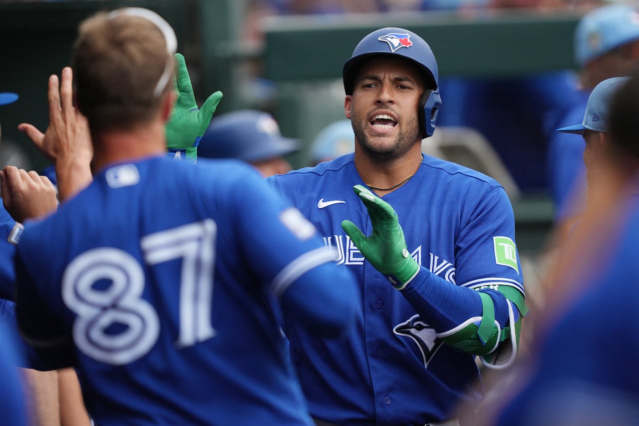 Blue Jays DH George Springer high fives teammates after hitting a home run during a spring training game