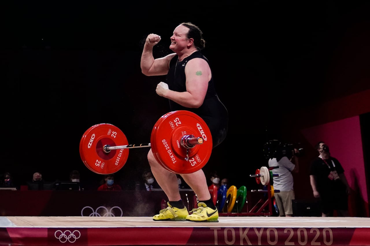 A person pumps their first in their while a large weight bounces below them