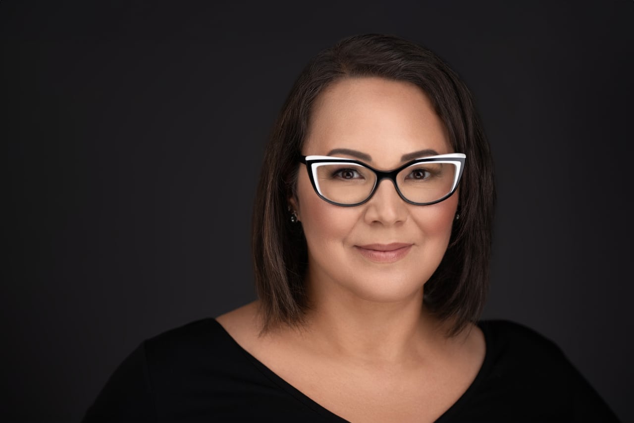 A woman with black and white glasses and a black shirt