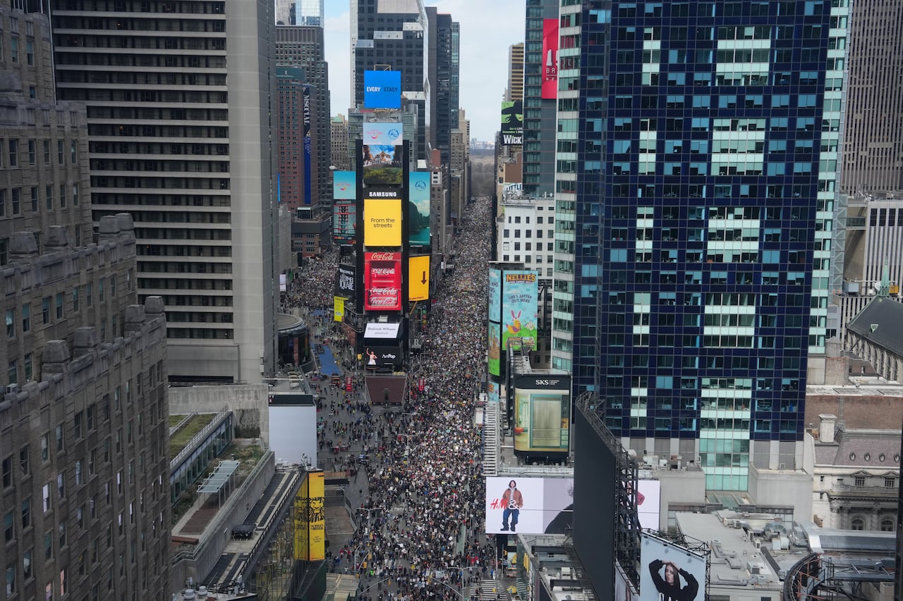 An aerial view shows protesters marching down a city street.