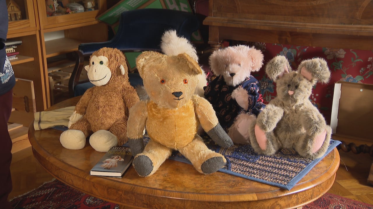 Five stuffed animals sit on a table in a home.
