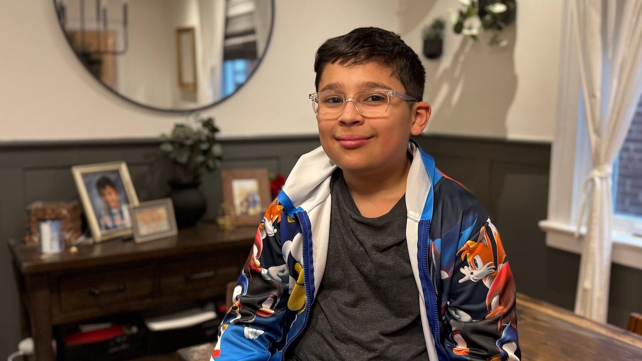 Nine-year-old boy sitting in his house.