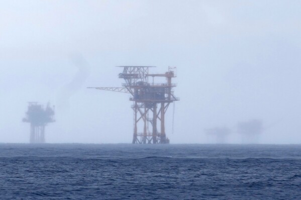 Oil platforms are visible through the haze near the Flower Garden Banks National Marine Sanctuary in the Gulf of Mexico, off the coast of Galveston, Texas, Sept. 16, 2023. (AP Photo/LM Otero, File)