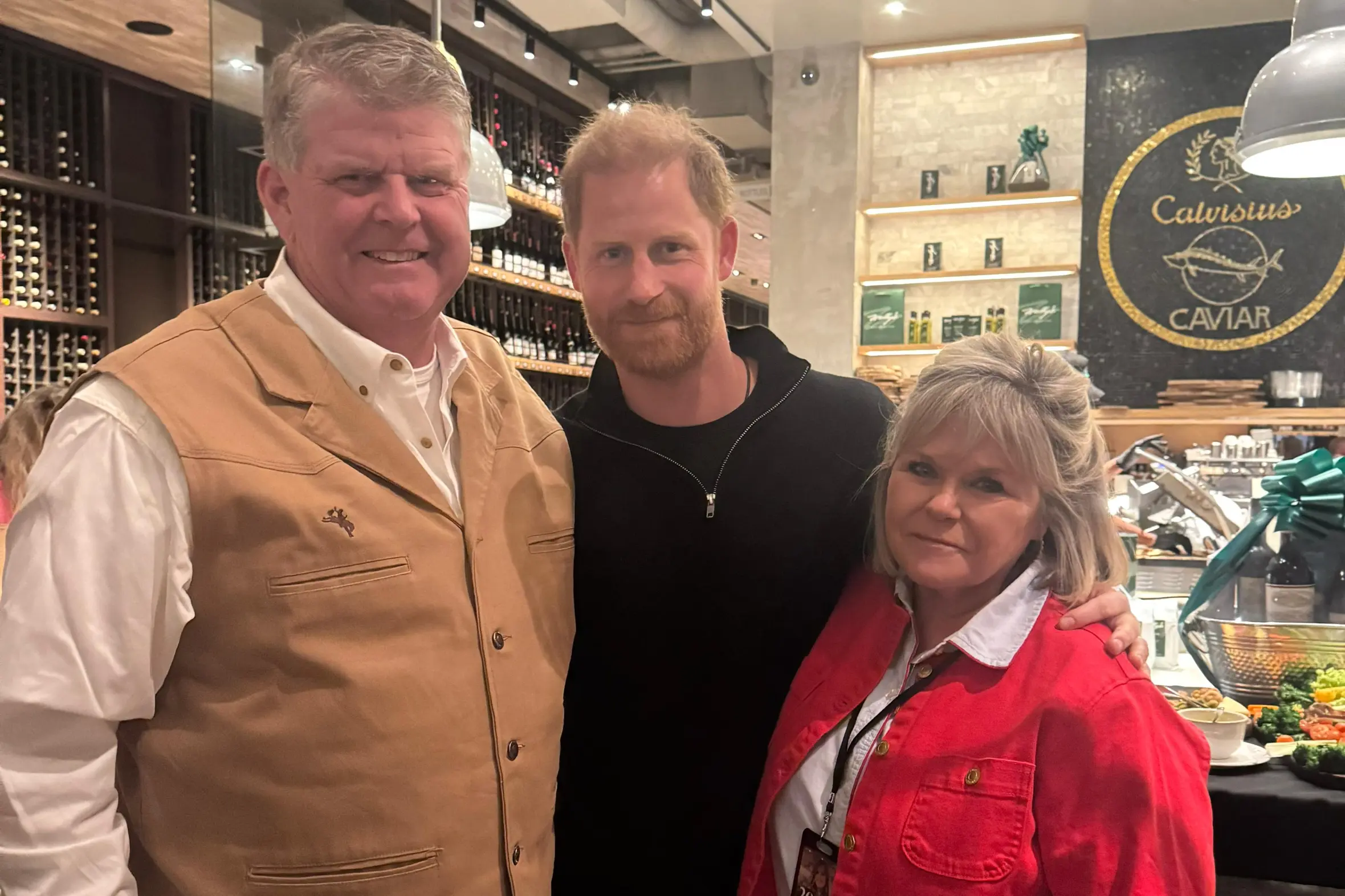 Prince Harry posing with Annalee's parents, Lori and Avery Schott.