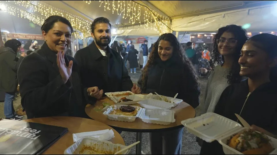 Visitors gather around a table to share food after breaking their fast at Ramadan Fest BC in Surrey.