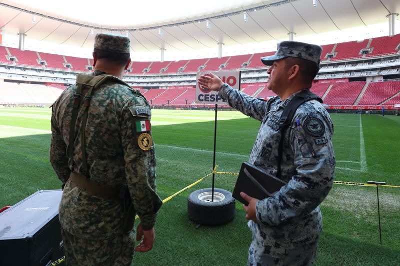 Soccer-Mexican fans enjoy a brief respite from violence as they gaze at World Cup trophy