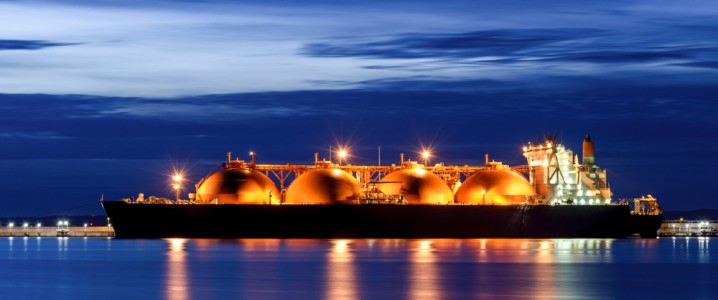 LNG tanker on the ocean lit up at night.